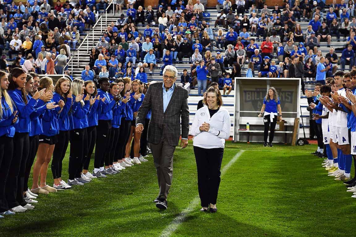 University President Fred P. Pestello, Ph.D, and First Lady Fran Pestello, Ph.D., walk on 博彩网址大全's soccer field to be honored before the men's game.