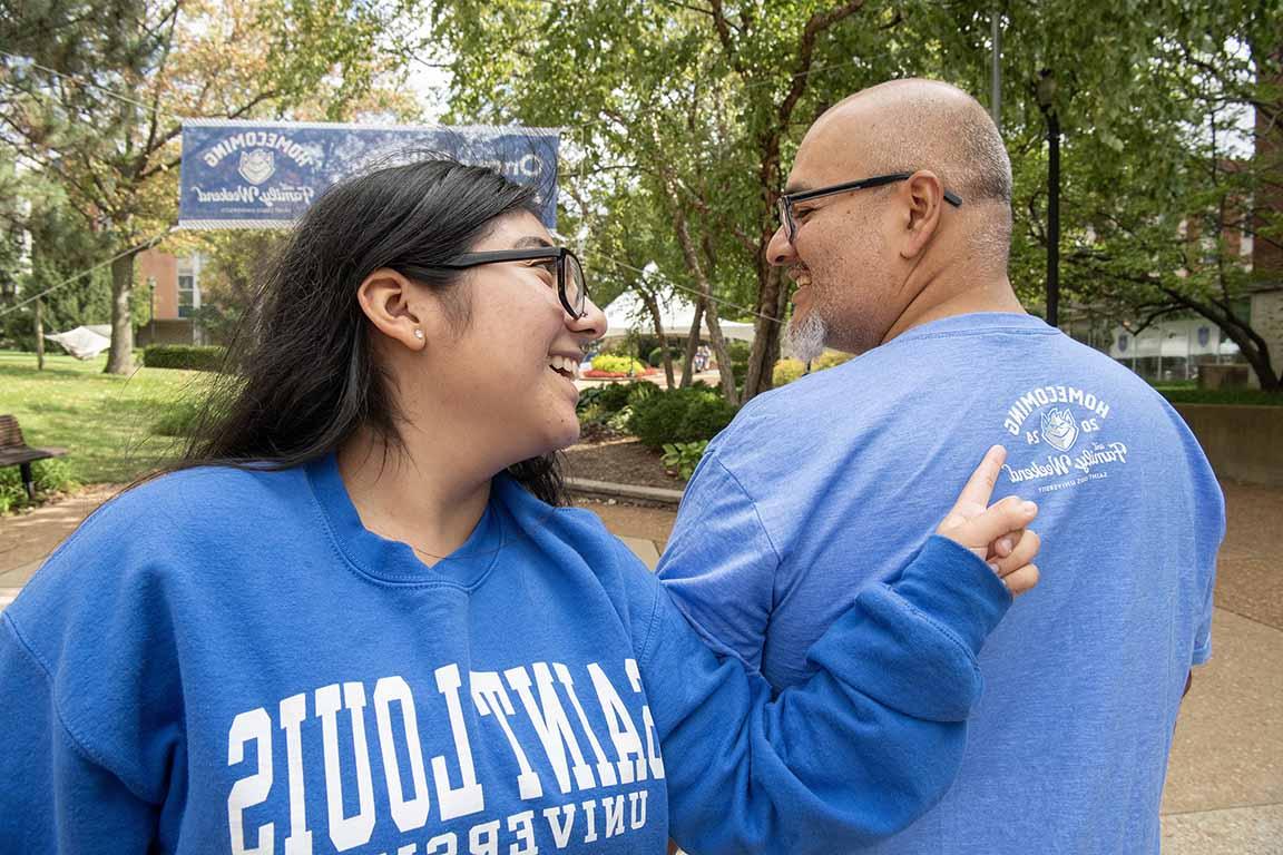 Attendees at 2024 Homecoming and Family Weekend stand on West Pine Mall in 博彩网址大全 gear pointing at each others' shirts.