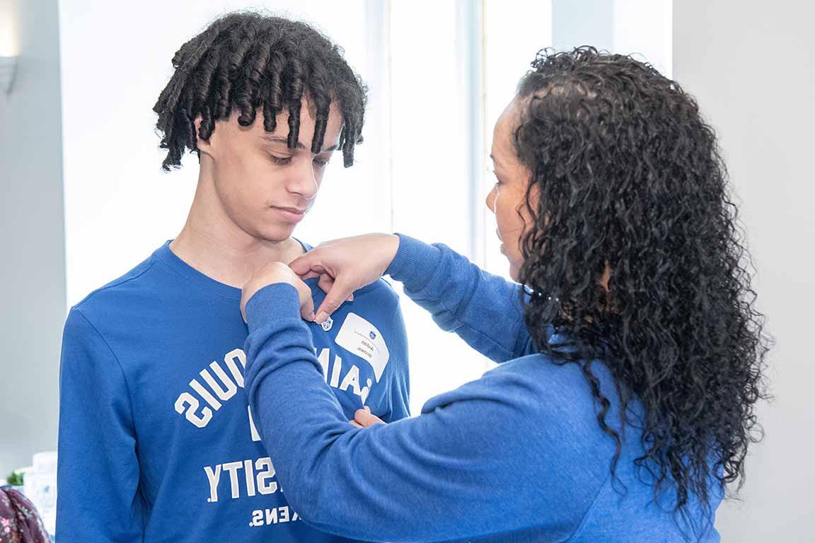 An alumnae pins a Saint Louis University pin on a legacy student at 博彩网址大全's 2024 Homecoming and Family Weekend Legacy Luncheon. 