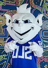 Billiken mascot in front of a graffiti wall