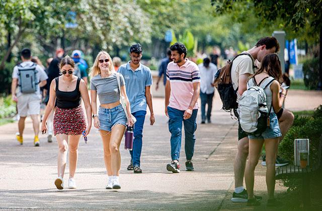 Two students walking together down a crowded pedestrian mall