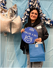 Sara Mosavi stands next to star-shaped balloons, holding a sign that reads "I am a BIlliken"