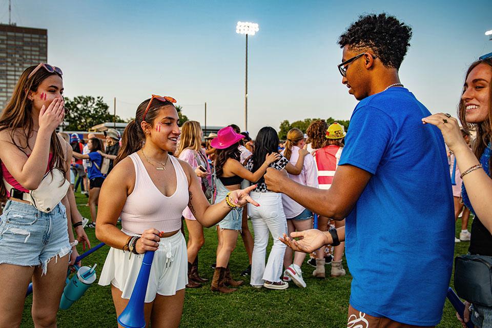 Students competing in rock, paper, scissors in Hermann Stadium